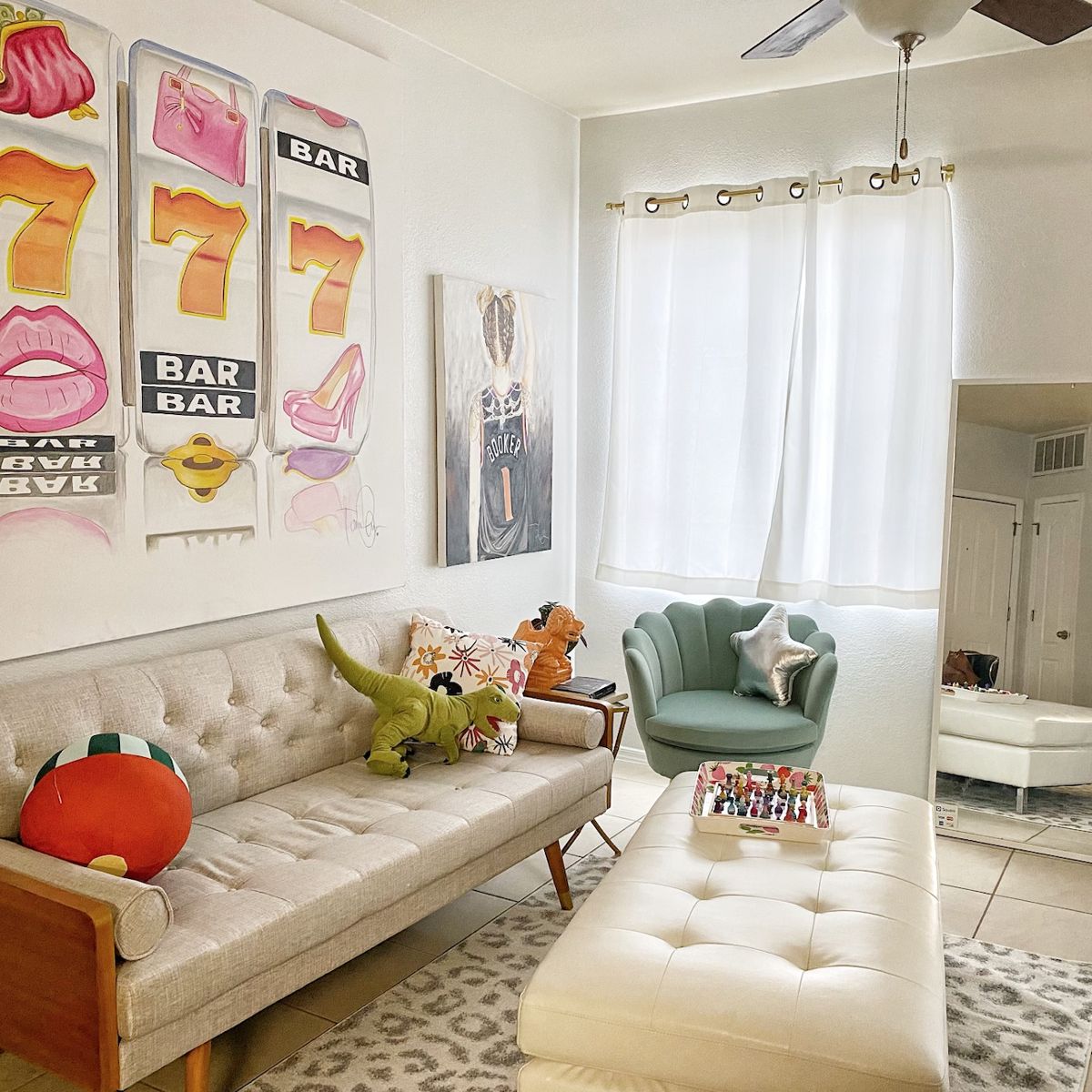 Living room styled with slot-machine and lips artwork above a cream sofa