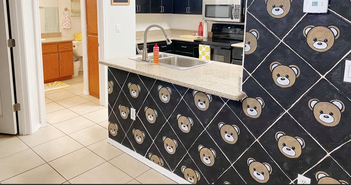 Kitchen with a hand-painted black-and-gold teddy bear pattern accent wall